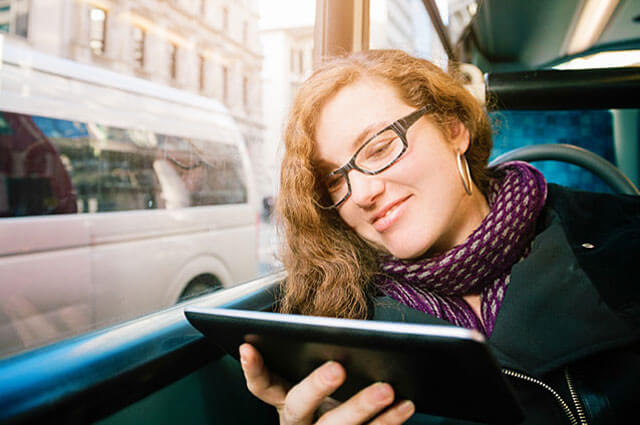 Woman sits on the bus reading a book